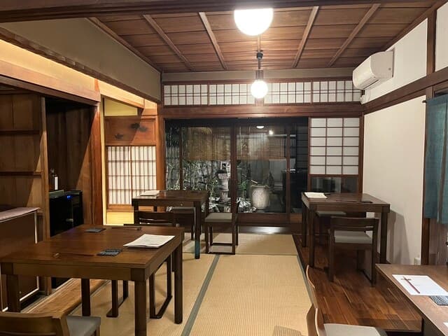 炭火と酒 心月 - 店内はカウンターと椅子席。奥に庭が見えて風情があります。
